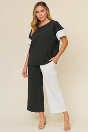 Short studio lookbook video of a black and white colorblock textured top with matching wide-leg pants and elastic waist.