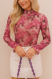 Short studio lookbook video of a pink floral mock-neck long-sleeve blouse with flounce cuffs, shown on-body.