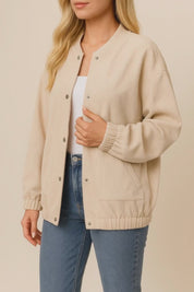 Short lookbook video of a khaki corduroy snap-button jacket with rib-knit stand collar, drop-shoulder sleeves, elastic cuffs and slant welt pockets, shown in studio lighting.