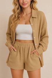 Short lookbook video of a tan crinkle button-up shirt & shorts set showing long sleeves, elastic-waist shorts and side-seam pockets, presented in studio lighting.