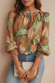 Green tropical leaf-print long-sleeve blouse with gathered crew neckline, smocked cuffs and relaxed drape — studio lookbook video