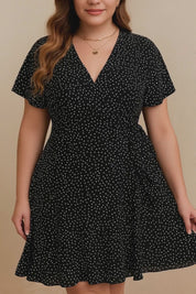Plus-size black polka-dot wrap mini dress with V-neck, flutter sleeves and tie waist — studio lookbook video
