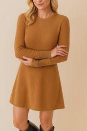 Short lookbook video showcasing a camel brown knit sweater dress with a crew neckline, long sleeves, clean center seam and soft A-line hem, shown from front, side and back in studio lighting.