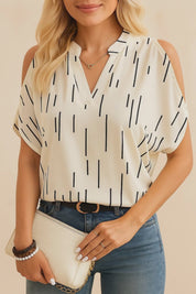 Short lookbook video of a white cold-shoulder blouse with contrast black trim and a notched V-neck; sleeve cut-outs and drape shown in studio