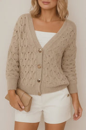Short lookbook video of a khaki textured V-neck cardigan showing the gold-tone button-front, soft balloon sleeves, and ribbed cuffs and hem in studio lighting.
