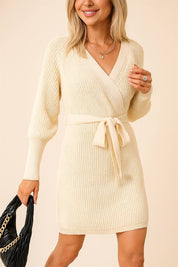Three-quarter front view of a women’s wrap sweater dress in ribbed knit featuring a cross-over V-neck bodice, self-tie waist, long sleeves and a cozy textured finish
