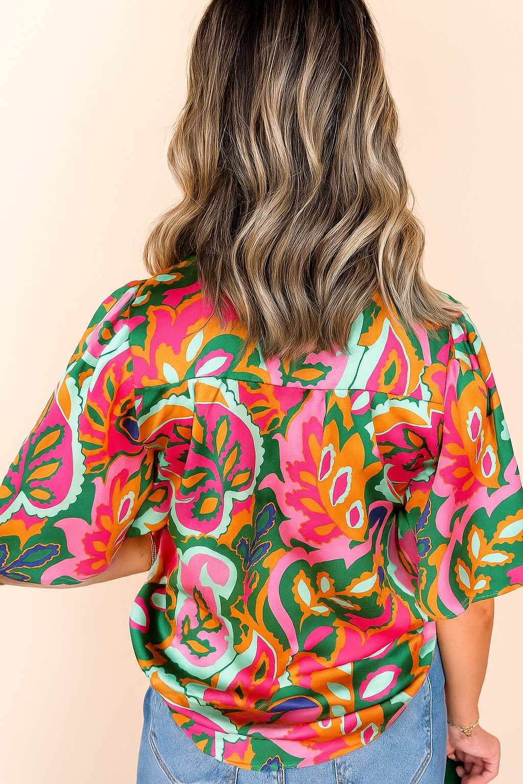 Back view of the rose-multi tropical print short-sleeve blouse showing the overall pattern and straight back hem