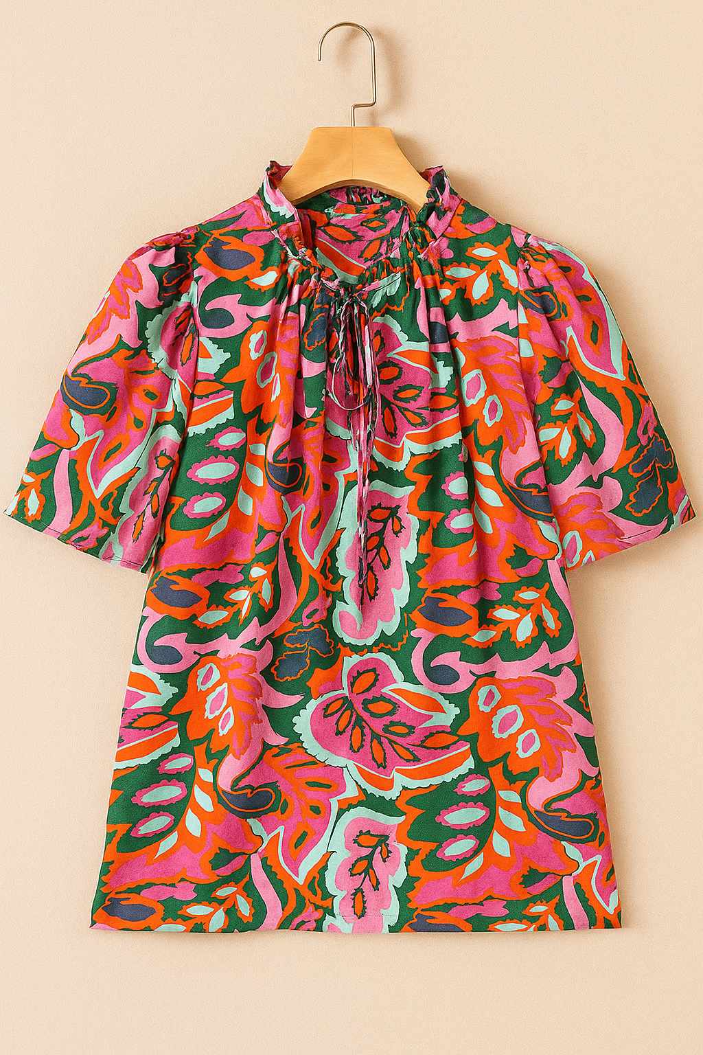 Hanger flatlay, front view of the rose-multi tropical print tie-neck short-sleeve blouse with ruffled collar