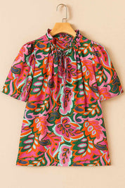 Hanger flatlay, front view of the rose-multi tropical print tie-neck short-sleeve blouse with ruffled collar