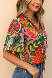Left side view of the rose-multi tropical print tie-neck short-sleeve blouse highlighting the sleeve shape and side profile.