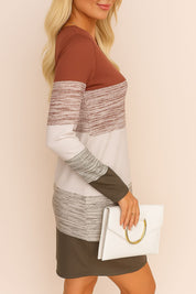 Side profile of a blonde woman in a long sleeve mini dress with earth-tone colorblocks and a white clutch – casual chic outfit