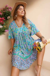 Sky-blue boho-print plus-size dress with lace V-neck and ruffled border — seated front view