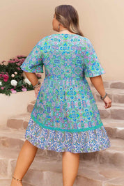 Sky-blue boho-print plus-size dress with clean back panel and ruffled hem — back view.