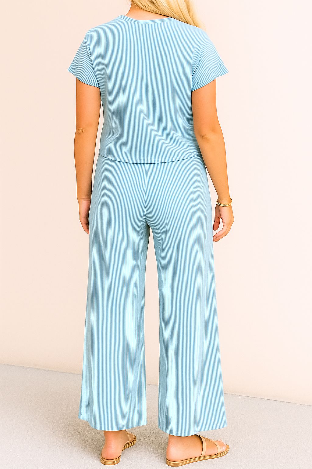 Back view of the sky-blue ribbed lounge set with a clean back panel on the top and relaxed drape through the wide-leg pants ending in a straight hem.