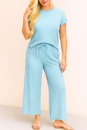 Straight-on front view of the sky-blue ribbed lounge set showing the round neckline, short sleeves, drawstring waist and easy wide-leg silhouette