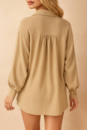 Back view of the tan crinkle set highlighting the shirt’s gathered back yoke and curved hem with cuffed long sleeves.