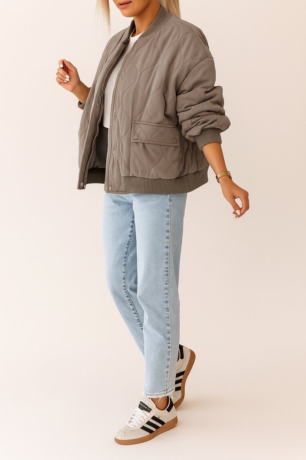 Front view of the taupe quilted bomber jacket showing rib-knit trim, zip and snap-front closure, and snap-flap hip pockets.