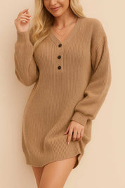 Close three-quarter front view of a women’s waffle-knit henley sweater dress with a V-neck and three-button placket, long balloon sleeves, ribbed cuffs and hem, and an easy above-knee fit.