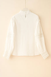 Hanger flatlay, back view of the white high-neck blouse with a small keyhole button at the neck and fine vertical texture; lace sleeve bands visible