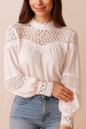 Front detail view of the white high-neck blouse highlighting the geometric lace yoke, scalloped neckline and lace cuff trim