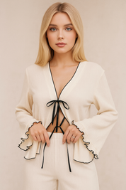 Women’s white tie-front bell-sleeve pajama set with ruffle hems and black contrast piping — front detail view.