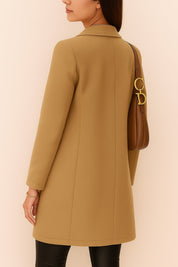 Back view of the camel longline coat with a smooth back panel, shaping center seam and clean mid-thigh hemline