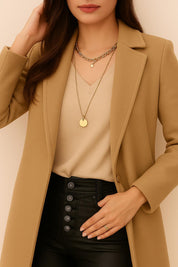 Front detail of the single-breasted coat highlighting the centered one-button placket, V-shaped front opening and smooth fabric