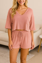 Women's waffle knit lounge set in peach pink, featuring V-neck top and matching drawstring shorts