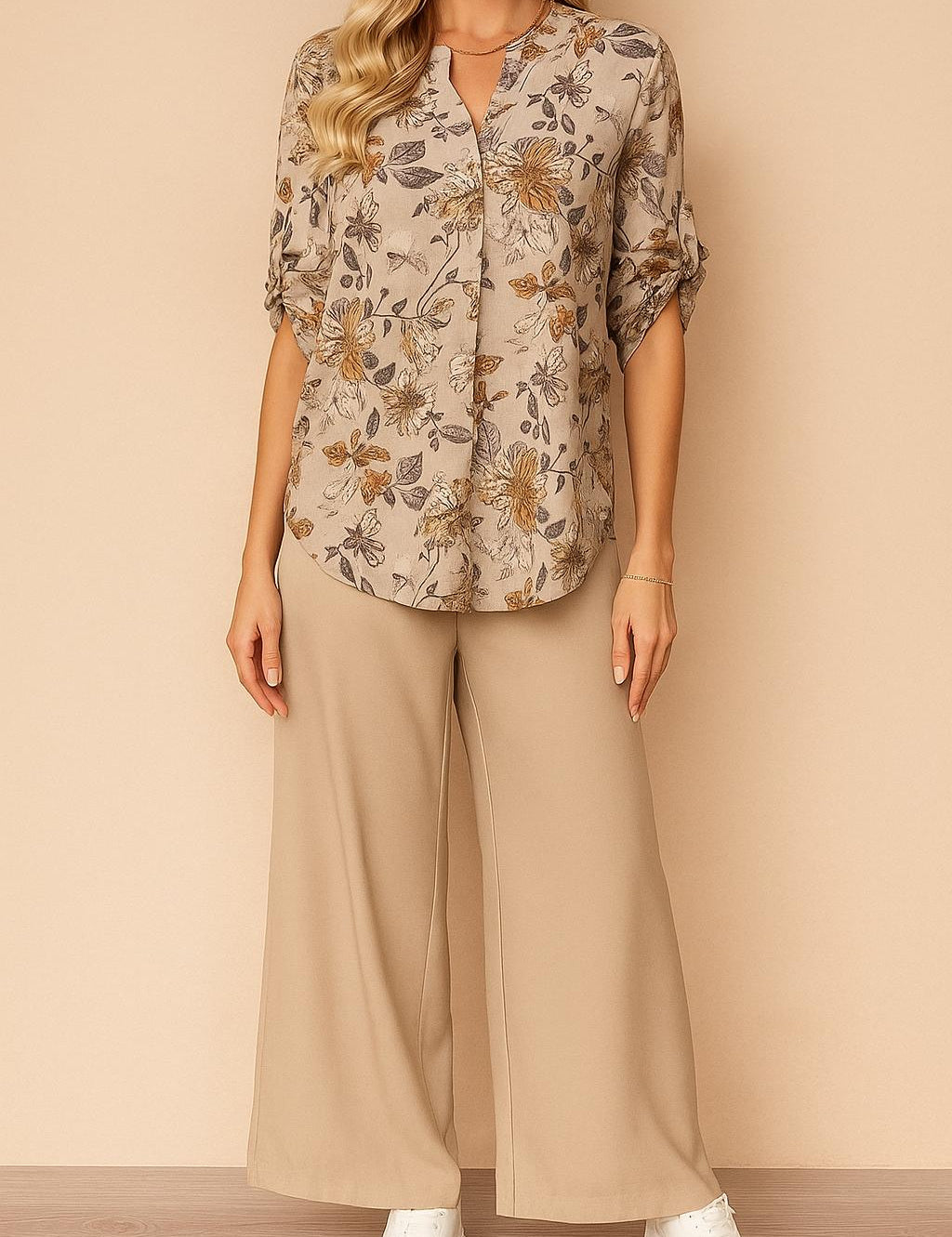 Two‑piece set — apricot floral split V‑neck blouse with roll‑tab sleeves and beige wide‑leg pants, relaxed drape — front view.