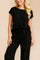 Front detail view of the black ribbed lounge set with exposed-seam crew-neck top and wide-leg pants.