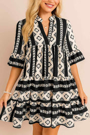 Women’s black-and-white boho geometric tiered mini dress with notched neckline and flared half sleeves — front view.