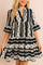 Women’s black-and-white boho geometric tiered mini dress with notched neckline and flared half sleeves — front view.