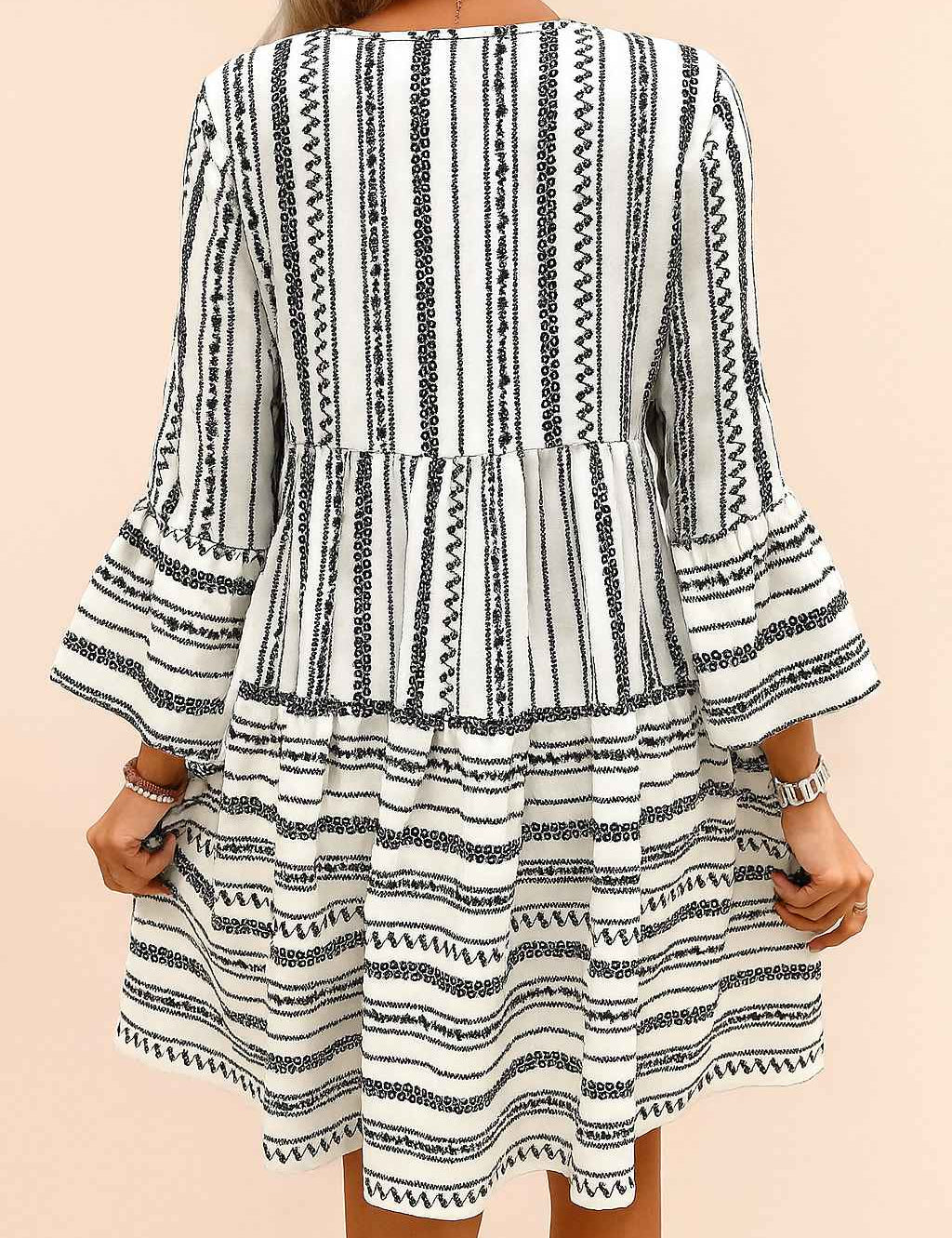 Black-and-white boho-print tie-neck mini dress with three-quarter flounce sleeves and clean back panel — back view.