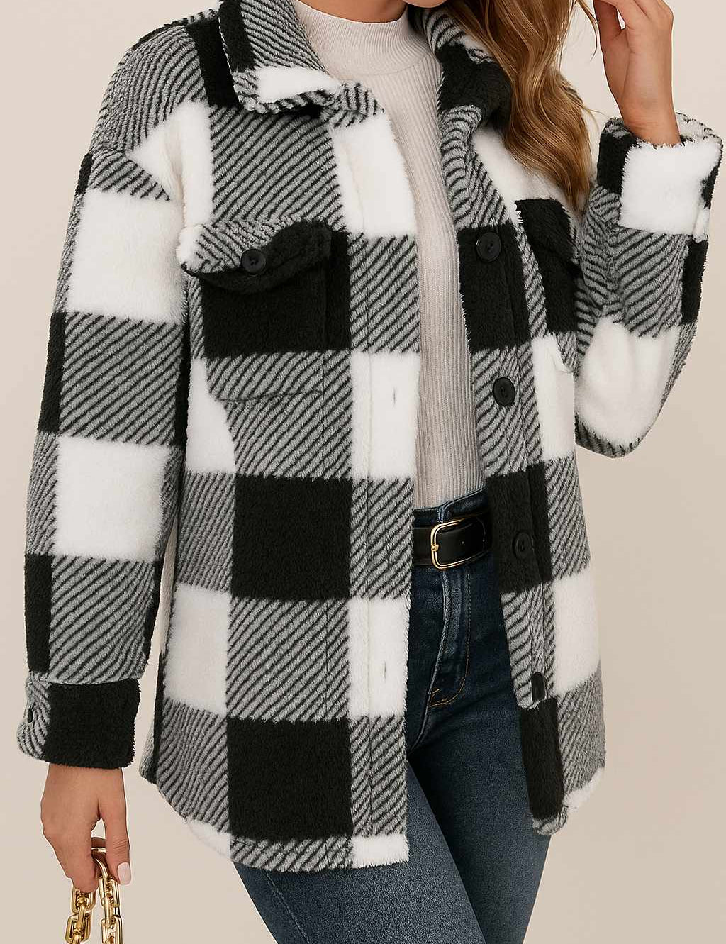 Front three-quarter view of a women’s black-and-white fuzzy plaid button-up jacket with a shirt collar, drop-shoulder long sleeves, flap chest pockets and a rounded hem.