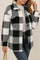Front three-quarter view of a women’s black-and-white fuzzy plaid button-up jacket with a shirt collar, drop-shoulder long sleeves, flap chest pockets and a rounded hem.