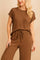 Front detail view of a women’s brown ribbed lounge set featuring an exposed-seam short-sleeve top and wide-leg pants with an elastic drawstring waist.