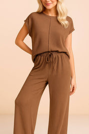 Relaxed front view of the brown ribbed lounge set with exposed-seam top and wide-leg trousers.