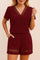 Front view of a burgundy eyelet-trim V-neck short-sleeve top with matching shorts; hem eyelet bands and side pocket entry visible.