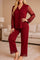 Woman in burgundy pajama set with full-length pants and sheer lace sleeves, elegant and comfortable nightwear
