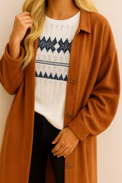 Front detail view highlighting the collar, button placket and textured finish on the caramel longline coat.