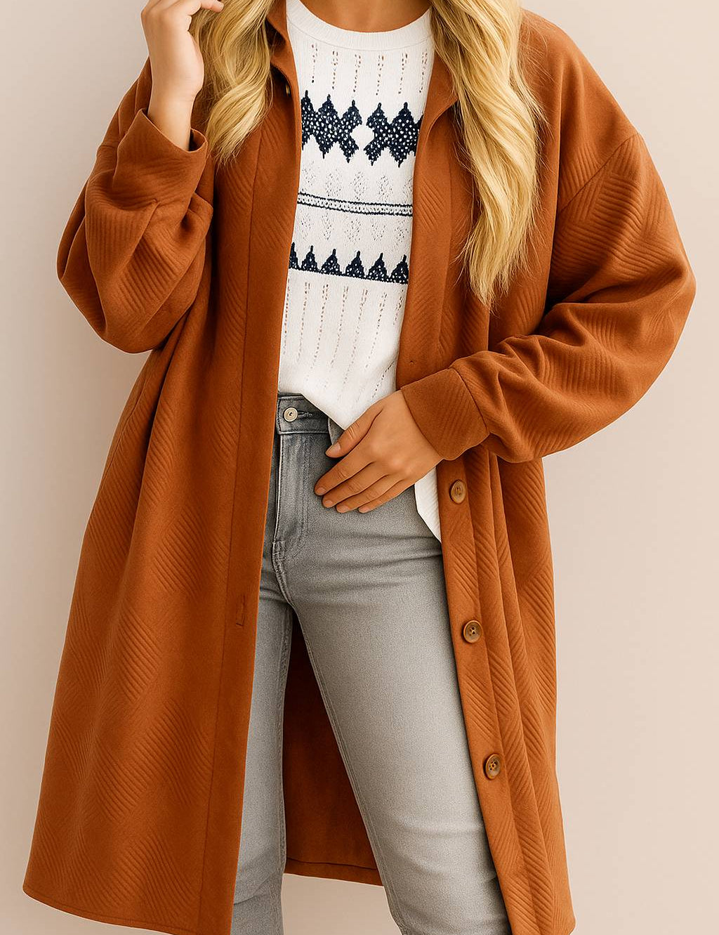 Front view of a women’s caramel textured button-down collared longline coat with drop-shoulder long sleeves and slant welt pockets; rounded straight hem.