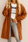 Front view of a women’s caramel textured button-down collared longline coat with drop-shoulder long sleeves and slant welt pockets; rounded straight hem.