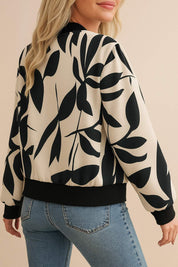 Back three-quarter view of the cream-and-black abstract-print bomber jacket showing the rib-knit hem and allover print.