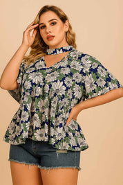 Front three-quarter view of the dark blue floral blouse showing the cutout choker neckline, flutter sleeves and softly flared hem