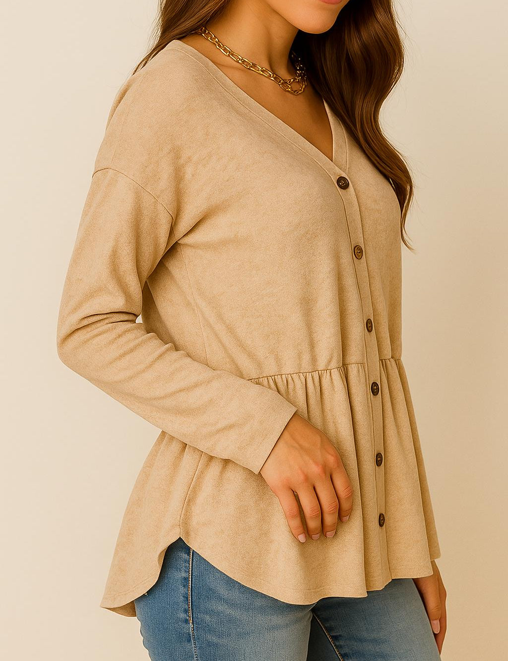 Left three-quarter view of the dust-storm beige V-neck button-front long-sleeve top showing the drop-shoulder cut and curved hem.