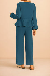 Back view of the dusty blue tie-front peplum blouse and wide-leg pants set; clean back panel and straight hem.