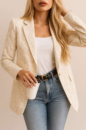 Front three-quarter view of an eggshell floral jacquard one-button blazer with notched lapel, long sleeves and a tailored fit.