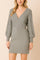 Front view of the women’s ribbed wrap sweater dress in heather gray with a deep V-neck, defined waist and cable-knit balloon sleeves; vertical ribs smooth the silhouette.