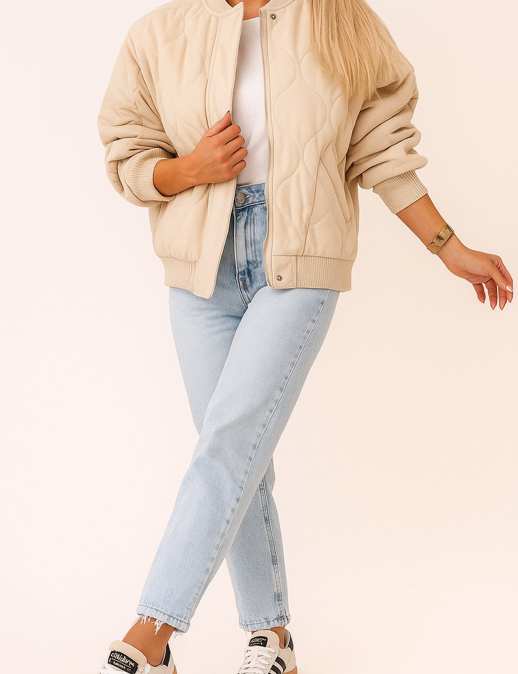 Front view of the ivory quilted bomber jacket with rib-knit collar, zip front covered by a snap-button placket, and snap-flap pockets