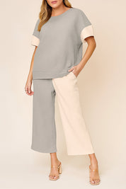 Centered front view of the light-gray and apricot colorblock textured top and matching wide-leg pants.